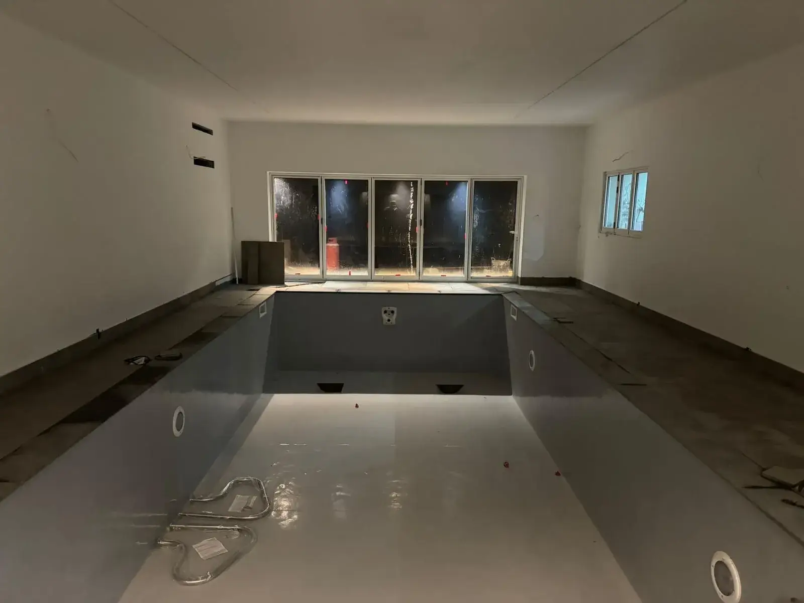 a view of a pool in a room with a window and a sink