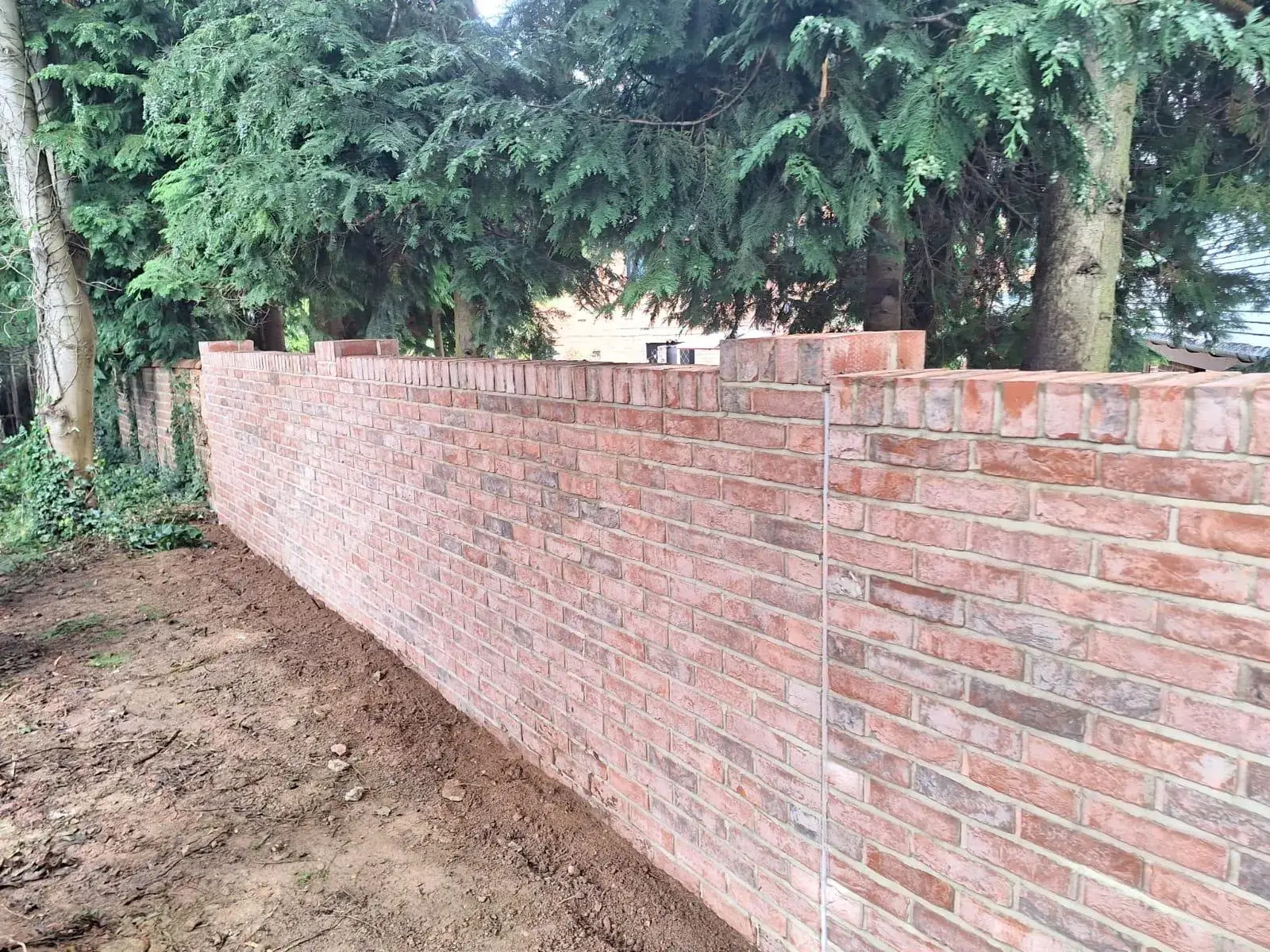 there is a brick wall that is being built in the yard
